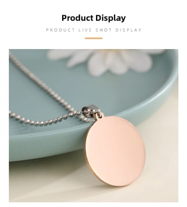 Macro detail of polished rose gold round pendant with ball chain on floral background