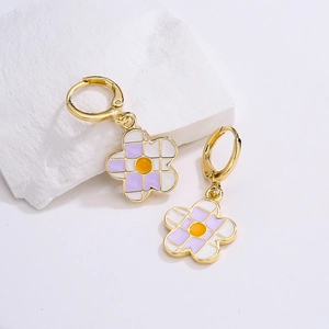 Detailed shot of 18K gold plated flower earrings with white and purple checkerboard enamel