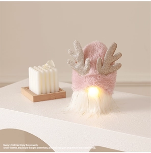 Detail of pink plush Christmas gnome with glowing nose and sequined reindeer antlers