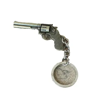 Vintage zinc alloy revolver pistol keychain with antique finish on a rustic burlap base