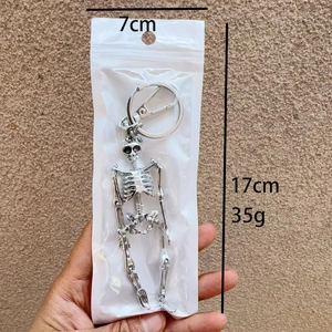 Detail shot of a silver metal skeleton keychain with dimensions showing 17cm length and 35g weight