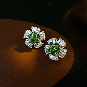Vue détaillée de boucles d'oreilles fleurs de luxe avec pierres vertes et diamants