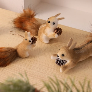 Three-piece set of foam squirrel ornaments with fluffy tails on a wooden surface
