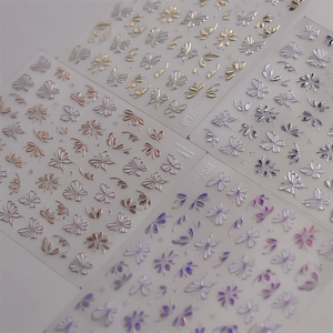 Detailed macro of 3D embossed gold and silver butterfly floral nail art stickers