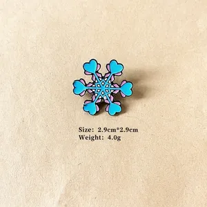 Close-up of snowflake enamel brooch with heart detail, size 2.9cm x 2.9cm, weight 4.0g