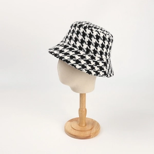 Close-up of houndstooth wool fisherman hat texture on a beige fabric mannequin stand