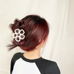 Detailed back view of model wearing a beige flower hair claw clip for elegant styling