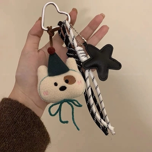 Dettaglio portachiavi a cucciolo di peluche con stella in pelle e corda intrecciata