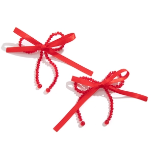Detail shot of red satin ribbon bow and translucent beads on fashion earring