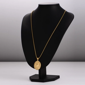 Gold oval pendant necklace featuring religious figure relief on a black mannequin display