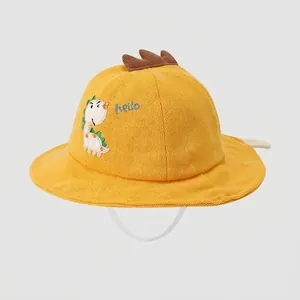 Close-up of ginger yellow cotton bucket hat with dinosaur embroidery and chin strap
