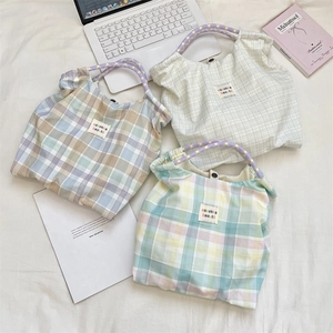 Flat lay of floral canvas tote bags with woven handles and minimalist woven labels