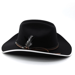 Detail of black wool felt cowboy hat with white bound edge, leather band and feather