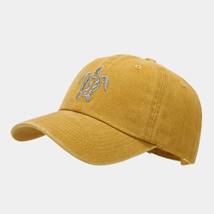 Detail of vintage ginger yellow cotton baseball cap with intricate turtle embroidery