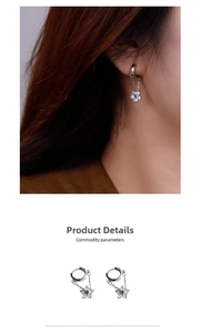 Detail of silver drop earrings with dainty zircon flower charms on long chains