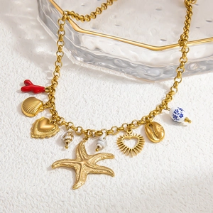 Detail of 18k gold starfish necklace with shells, coral, and blue floral ceramic bead