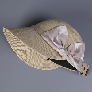 Straw sun hat in light beige with large purple satin bow and wide brim for sun protection