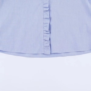 Detail of blue and white striped poplin shirt with ruffled edges and curved hem