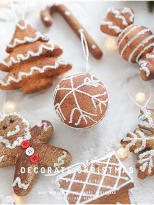 Detailed view of gingerbread man and star foam ornaments on a snowy backdrop