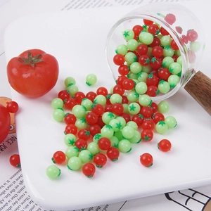 Miniature di pomodori rossi e verdi che cadono da un bicchiere su un vassoio bianco