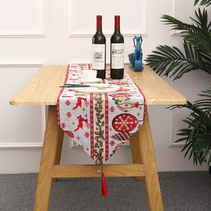Close-up of knitted Christmas table runner with reindeer patterns and red tassels