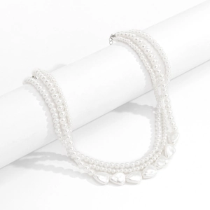 Close-up of triple-layered baroque pearl necklace with elegant round and irregular pearls