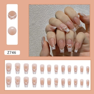 French tip press-on nails with white cross stripes, pearls, and a blush pink glossy finish