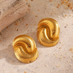 Textured 18K gold plated hoop earrings with shell spiral design on natural beach sand