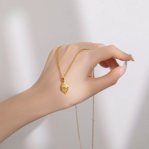 Elegant gold leaf pendant necklace with micro-pave diamonds on a titanium steel chain