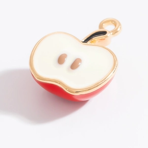 Vue détaillée du pendentif pomme rouge avec chair blanche et bords dorés polis