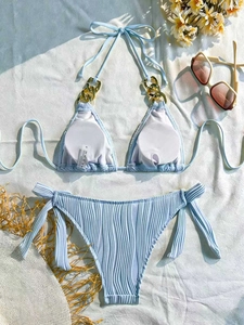 Detail of light blue ribbed bikini featuring golden chain straps and textured fabric