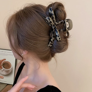 Detailed back view of a chic leopard print bow hair claw clip in a stylish updo style