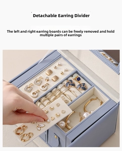 Detail showing the removable earring panels and beige velvet interior of the jewelry box