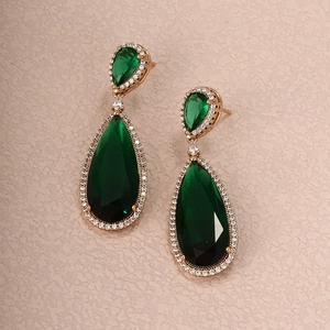 Detail of vintage emerald waterdrop earrings with small zircons in gold plating