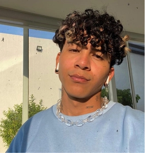 Close-up of clear acrylic chunky chain necklace and matching earrings on male model