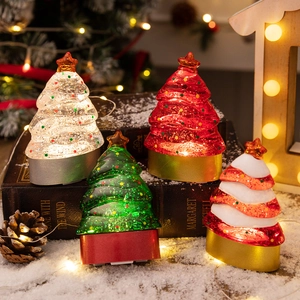 Set of four glowing LED Christmas tree desk ornaments in festive colors on vintage books