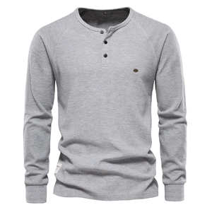 Gros plan sur le tissu gaufré gris clair et le col Henley à trois boutons pour homme