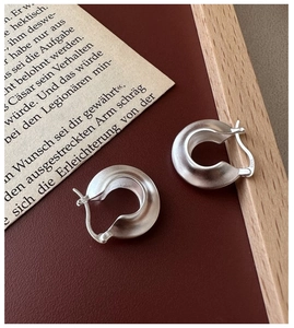 Detailed macro view of S925 sterling silver hoop earrings with a matte brushed finish
