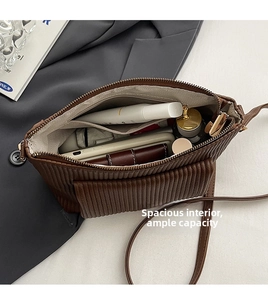 Interior view showing the large capacity of the brown pleated bag with personal items