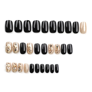 Black press-on nails set with gold glitter and 3D champagne rhinestones on white background