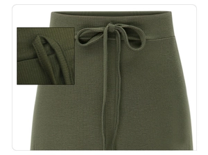Close-up of dark green ribbed knit skirt featuring drawstring waist and fabric texture