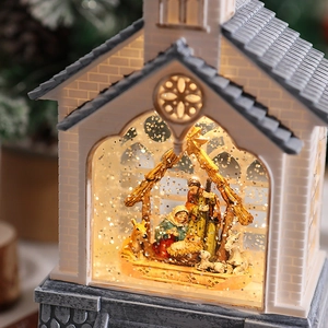 Close-up of LED lit Nativity scene inside a church-style lantern with floating glitter