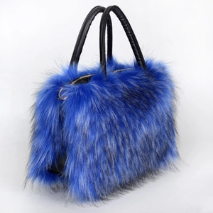 Detail of blue faux fur tote bag showing the fluffy texture and black leather handles