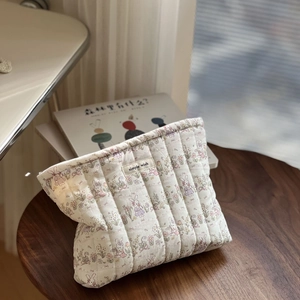 Close-up of quilted cotton cosmetic bag featuring rabbit prints and simple wish label