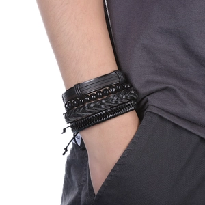 Gros plan d'un ensemble de quatre bracelets multicouches en cuir tressé noir pour homme