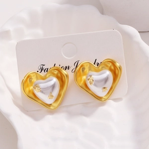Détail de boucles d'oreilles en forme de cœur plaquées or 18 carats avec perles