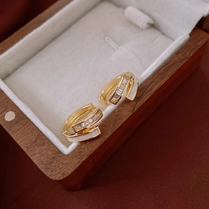 Close-up of gold-plated double-layer earrings with cubic zirconia in a velvet box