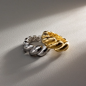 Macro detail of gold and silver croissant rings with twisted design and polished finish