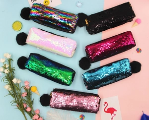 Flat lay of sequin pencil cases in seven colors with a fluffy pompom keychain detail