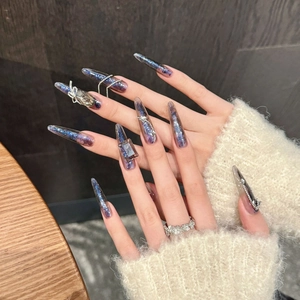 Faux ongles stiletto noirs avec papillon, breloques croisées et paillettes violettes